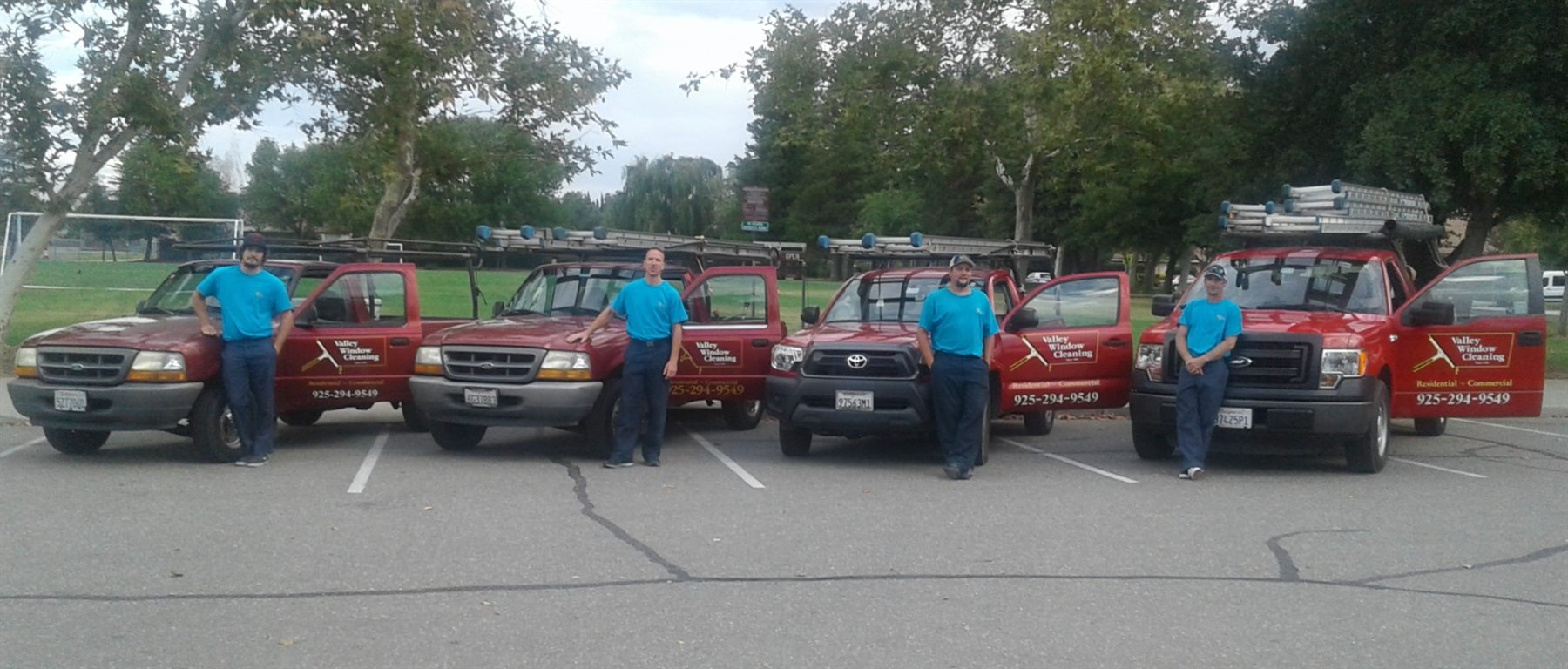 The Valley Window & Gutter Cleaning team with their red branded trucks