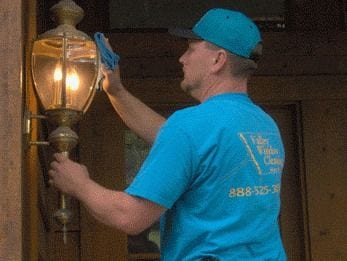 Technician cleaning a brass exterior entry lantern