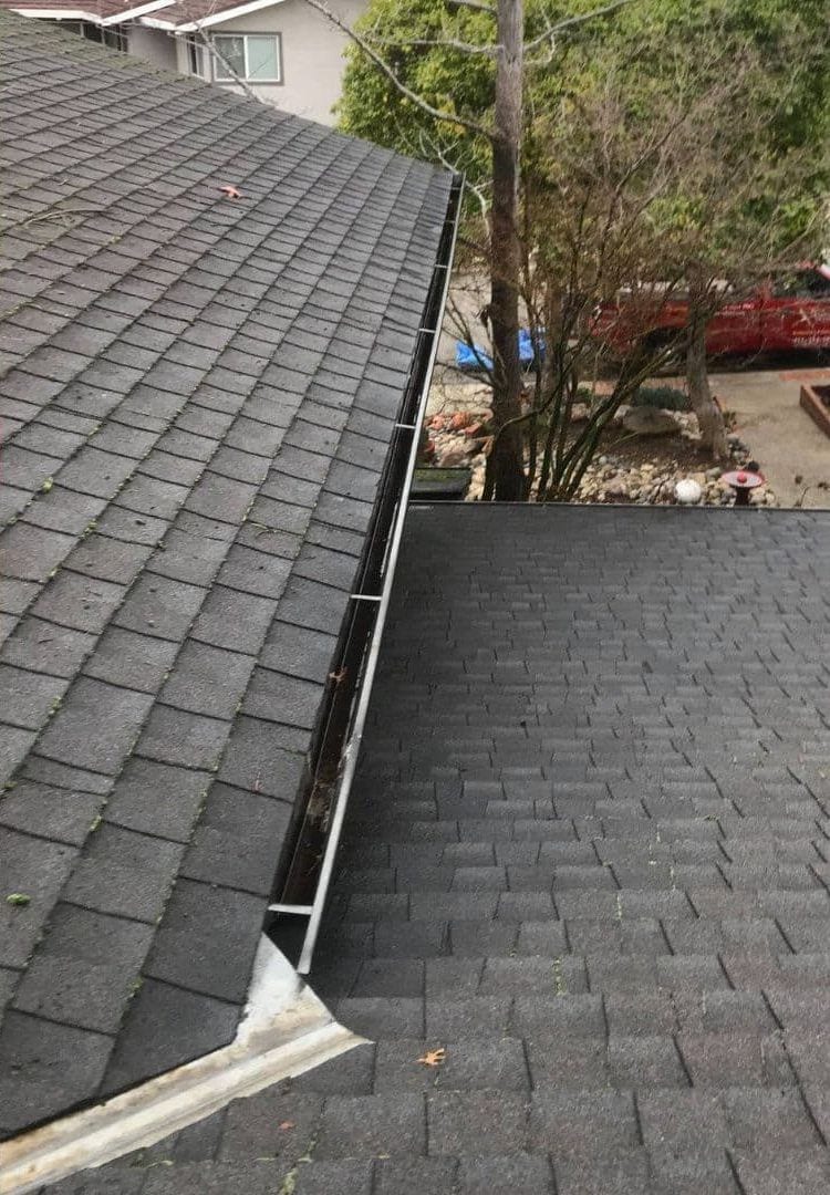 The same roofline with the gutter cleared of debris after cleaning
