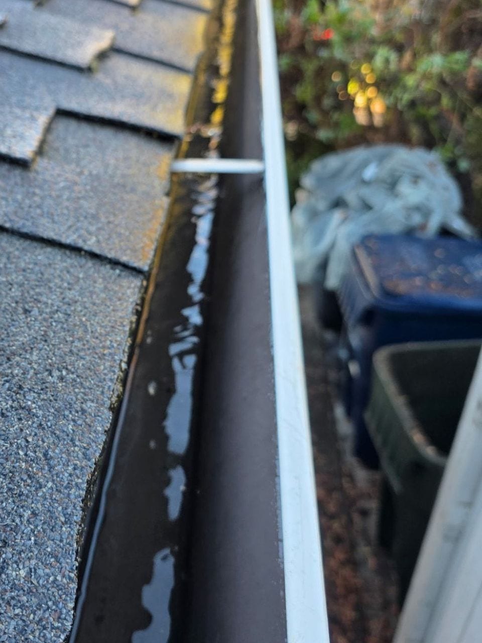 The same roof edge gutter after cleaning, clear of leaves and debris