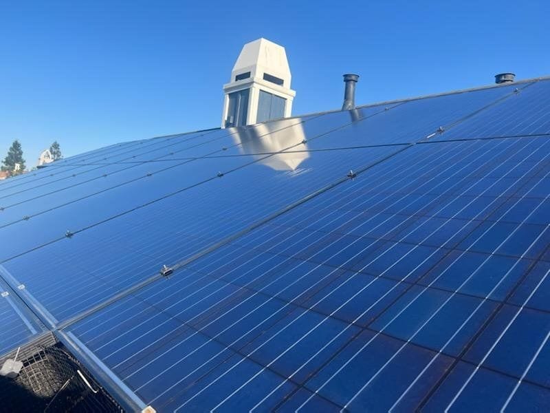 Clean rooftop solar panels under a clear blue sky